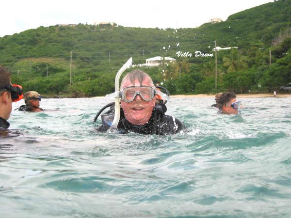 SCUBA Diver in the water with Villa Dawn in the background.