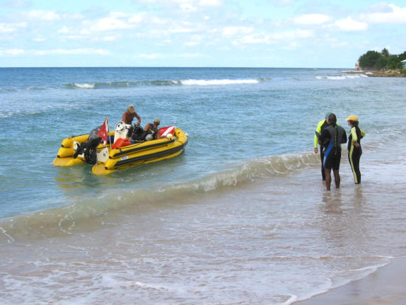 Cane Bay Dive Shop boat at the beach with SCUBA divers.